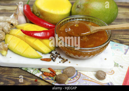 Schüssel mit hausgemachten Frsh Mango-Chutney auf alten Holztisch Stockfoto