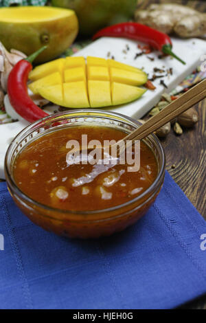 Schüssel mit hausgemachten Frsh Mango-Chutney auf alten Holztisch Stockfoto