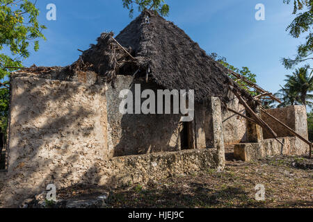 Mittelalterliche primitive großes Haus mit Strohdach, gebaut von lokalen Ureinwohner, ausgefertigt von Holzstäbchen, tote Korallen und der rote Boden (keine Ziegel), Zanzibar Stockfoto