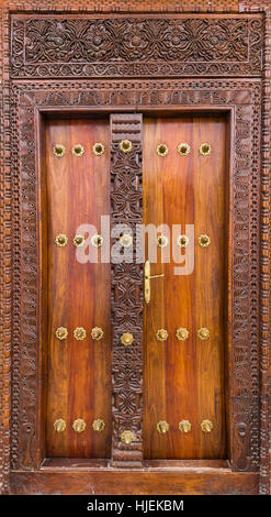 Holz- und verzierten braunen Türen der reichen Haus mit gelben Metall Messing-Nieten, arabischen Design, Stonetown, Sansibar, Tansania, Afrika Stockfoto