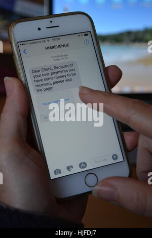 Person Blick auf einen Scam / Phishing SMS auf mobilen Gerät empfangen. Stockfoto