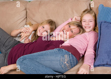Liebevolle Mutter verbringt Zeit mit ihren Töchtern zu Hause. Stockfoto