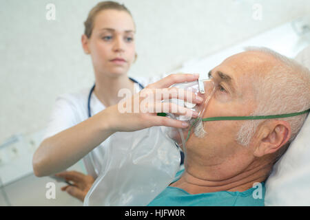 Krankenschwester Platzierung Sauerstoffmaske auf Patienten Stockfoto