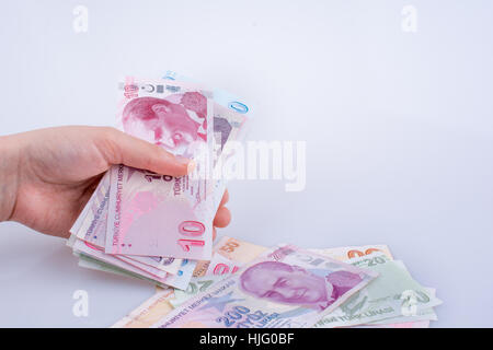 Hand hält Turksh Lira-Banknoten auf weißem Hintergrund Stockfoto