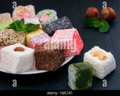 Turkish Delight auf schwarzem Hintergrund rustikal. Türkische Deligh Satz. Verschiedene traditionelle Lokum auf orientalische dunklen Hintergrund Stockfoto