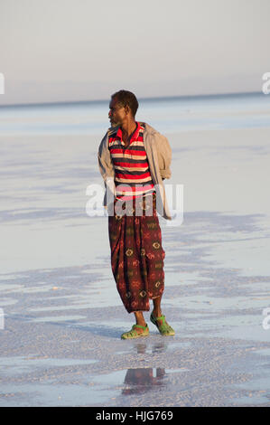 Der Ferne wandte sich Mann, Gesicht, Stand auf dem seichten Wasser der Salinen in Dallol, Danakil-Senke, Äthiopien Stockfoto