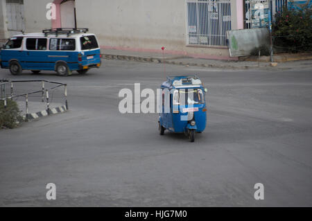 Bajaj in Indien machte als öffentliche Verkehrsmittel in Mekelle, Äthiopien, gefolgt von einem Minibus-Taxi blau und weiß Stockfoto