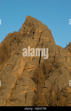 Robuste Stein Berg mit vertikalen Risse und spärlicher Vegetation mit tiefblauem Himmel. Fotografiert in der Mongolei. Stockfoto