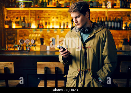 Man prüft e-Mails auf dem Handy in der bar Stockfoto