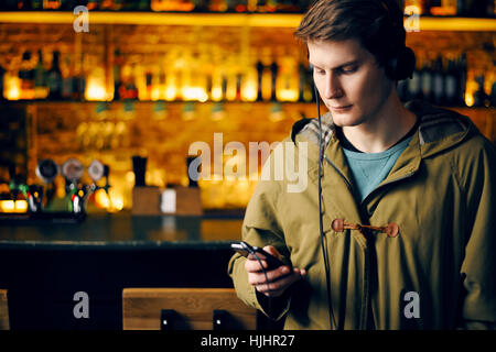 Man prüft e-Mails auf dem Handy in der bar Stockfoto