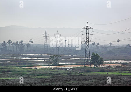 Morgen-Szene der massive Stromleitungen, überqueren eine sumpfige Gebiet auf Land in Indien Stockfoto