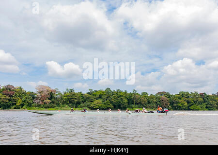 Eine hölzerne Einbaum mit Außenbordmotor befestigt, auf dem Sepik Fluss in Papua-Neuguinea. Es gibt acht Menschen an Bord. Stockfoto