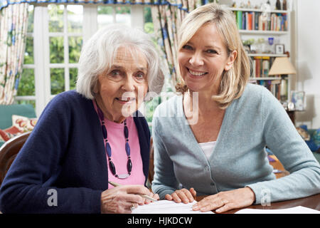 Weibliche Nachbarn helfen Senior Frau Formular ausfüllen Stockfoto