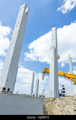 Kranarm ist bereit für den Betrieb, Montage Betonsäulen auf neue Gebäude. Stockfoto