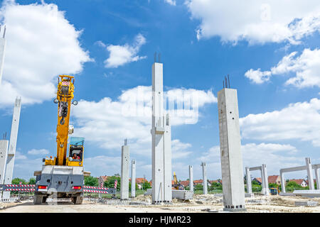 Kranarm ist bereit für den Betrieb, Montage Betonsäulen auf neue Gebäude. Stockfoto