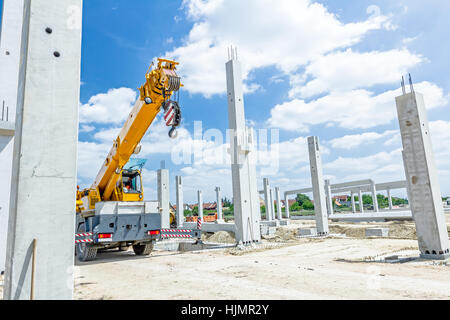 Kranarm ist bereit für den Betrieb, Montage Betonsäulen auf neue Gebäude. Stockfoto