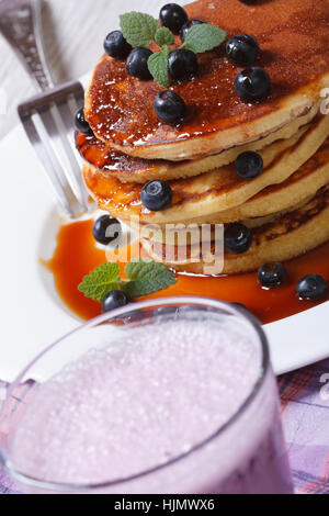 Blueberry cocktail und Pfannkuchen mit Beeren und Ahornsirup auf die Tabelle Closeup. vertikale Stockfoto
