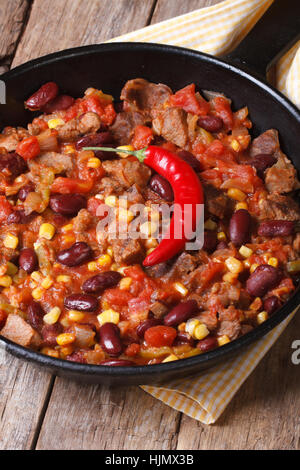 Chili Con Carne Nahaufnahme in einer Pfanne auf einem hölzernen Hintergrund. vertikale Stockfoto