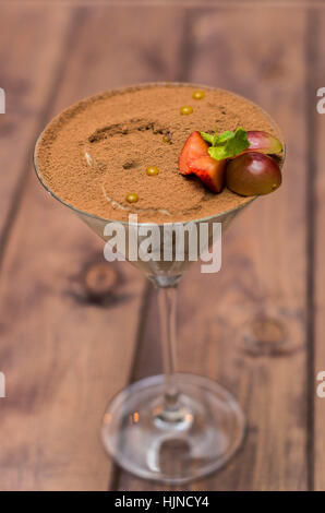 Tiramisu im Glas auf einem hölzernen Hintergrund mit Beeren Stockfoto