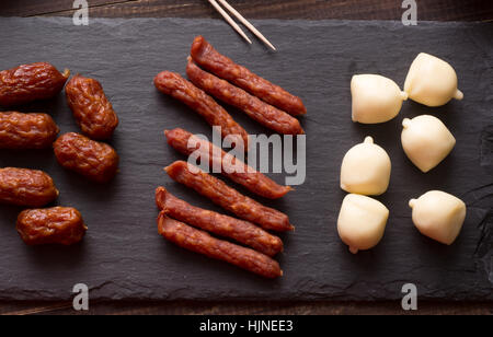 Mini getrocknet und geräuchert, Wurst und Käse auf schwarzem Schiefer Steinplatte Stockfoto