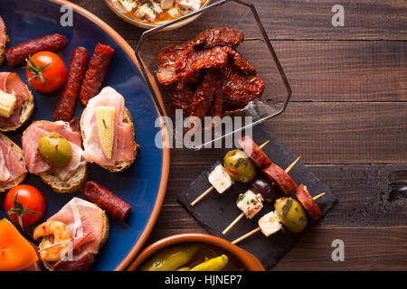 Auswahl an mediterranen snacks auf alten Holztisch. Tapas oder Antipasti. Ansicht von oben Stockfoto