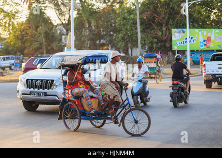 TOAMASINA, Madagaskar - 17. Oktober 2016: Traditionelle Rikscha Fahrrad mit madagassischer Völker in Madagaskar zweitgrößte Stadt Toamasina. Gewöhnliche str Stockfoto