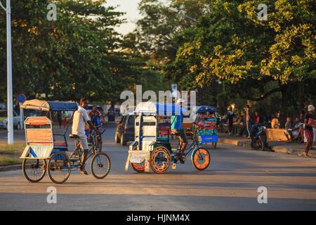 TOAMASINA, Madagaskar - 17. Oktober 2016: Traditionelle Rikscha Fahrrad mit madagassischer Völker in Madagaskar zweitgrößte Stadt Toamasina. Gewöhnliche str Stockfoto