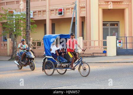 TOAMASINA, Madagaskar - 17. Oktober 2016: Traditionelle Rikscha Fahrrad mit madagassischer Völker in Madagaskar zweitgrößte Stadt Toamasina. Gewöhnliche str Stockfoto
