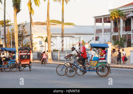 TOAMASINA, Madagaskar - 17. Oktober 2016: Traditionelle Rikscha Fahrrad mit madagassischer Völker in Madagaskar zweitgrößte Stadt Toamasina. Gewöhnliche str Stockfoto