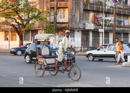 TOAMASINA, Madagaskar - 17. Oktober 2016: Traditionelle Rikscha Fahrrad mit madagassischer Völker in Madagaskar zweitgrößte Stadt Toamasina. Gewöhnliche str Stockfoto