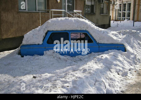 Blaues Auto mieten mit Schnee bedeckt Stockfoto