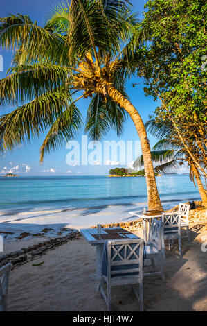 Strand der Seychellen mit Tisch und Stühlen, Insel Praslin, Strand Anse Volbert Stockfoto