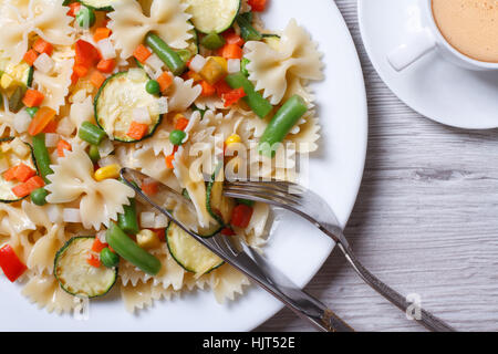 Leckeres Mittagessen von Farfalle Nudeln mit Gemüse und Kaffee Closeup on White. horizontale Ansicht von oben Stockfoto