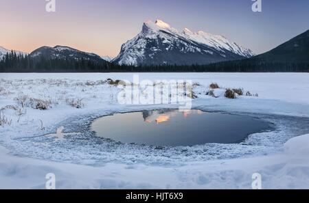 Vermilion Lakes, entfernte Rundle Mountain Winterlandschaft malerische Aussicht und Sonnenuntergang Himmel im Banff Nationalpark der Kanadischen Rockies Stockfoto
