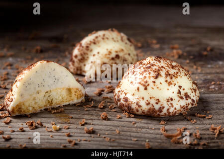 Zwei Vanille Perle Süßigkeiten, einem halbieren und geriebene dunkle Schokolade auf hölzernen Hintergrund Stockfoto