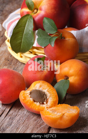 Aprikosen-close-up auf einem Hintergrund von einem Korb mit Obst auf dem Tisch. vertikale Stockfoto