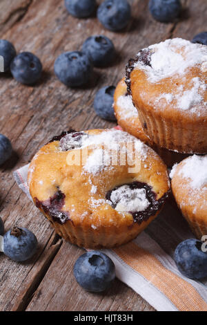 Leckere Muffins mit Heidelbeeren hautnah auf einem alten Holztisch. vertikale Stockfoto