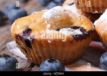 Leckere Blaubeer-Muffins mit Puderzucker auf einem Holztisch Makro. horizontale Stockfoto