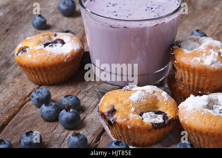 Muffins mit Heidelbeeren und Milch cocktail mit Beeren auf Holztisch Nahaufnahme horizontal Stockfoto