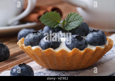 Törtchen mit Heidelbeeren und Sahne Closeup auf Holztisch horizontale Stockfoto