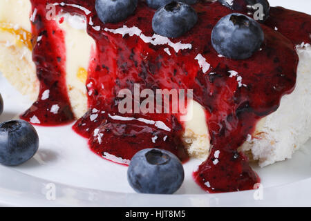 Blaubeer-Käsekuchen mit Beerensauce auf einer horizontalen Platte-Makro Stockfoto