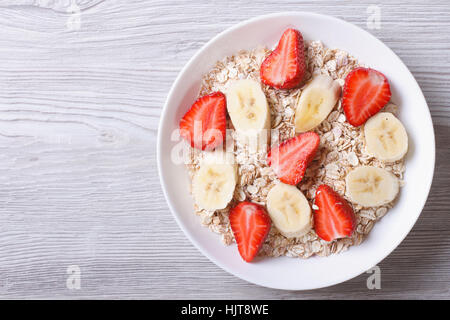 Müsli mit frischen Erdbeeren und Bananen Closeup on White. horizontale Ansicht von oben Stockfoto
