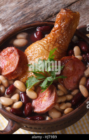 rote und weiße Bohnen mit Hähnchenschenkel und Würstchen in einer Schüssel auf dem Tisch. vertikale hautnah Stockfoto