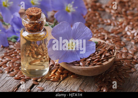 Leinsamen in einen Löffel und Öl in der Flasche auf den Tisch close-up horizontalen Stockfoto