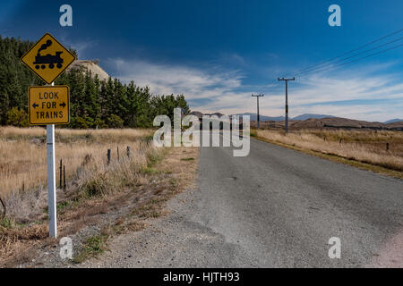 Landstraße und Eisenbahn mit Blick auf den fernen Horizont. Südinsel, Neuseeland. Stockfoto