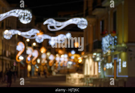 Typische Weihnachtsbeleuchtung an einer Hauptstraße der Stadt Pozzuoli in der Provinz Neapel. Die hellen Dekorationen sind teilweise über die r ausgesetzt. Stockfoto