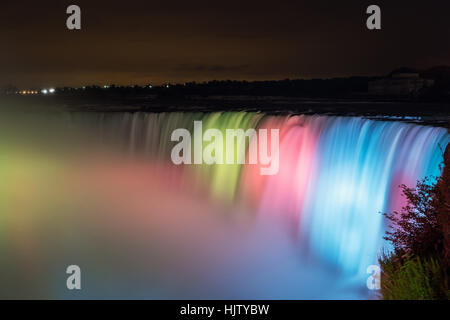 Langzeitbelichtung der tosenden Niagara-Fälle beleuchtet in der Nacht in verschiedenen Farben Stockfoto