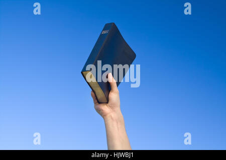 Hand, die Bibel über blauen Himmel Stockfoto