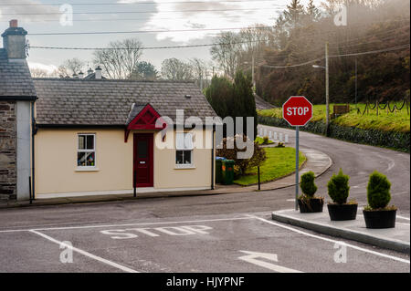 Eine malerische Bungalow an einer Straßenkreuzung mit einem Stop-Schild und textfreiraum in West Cork, Irland. Stockfoto