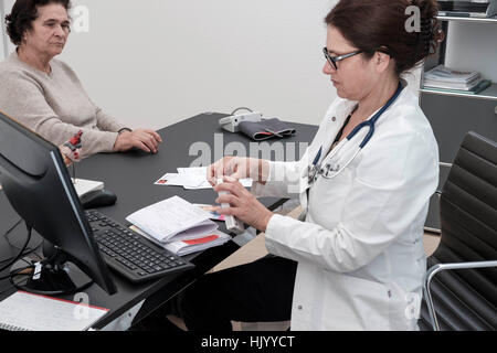 Doktor, der Medikation zu den älteren weiblichen Patienten Stockfoto